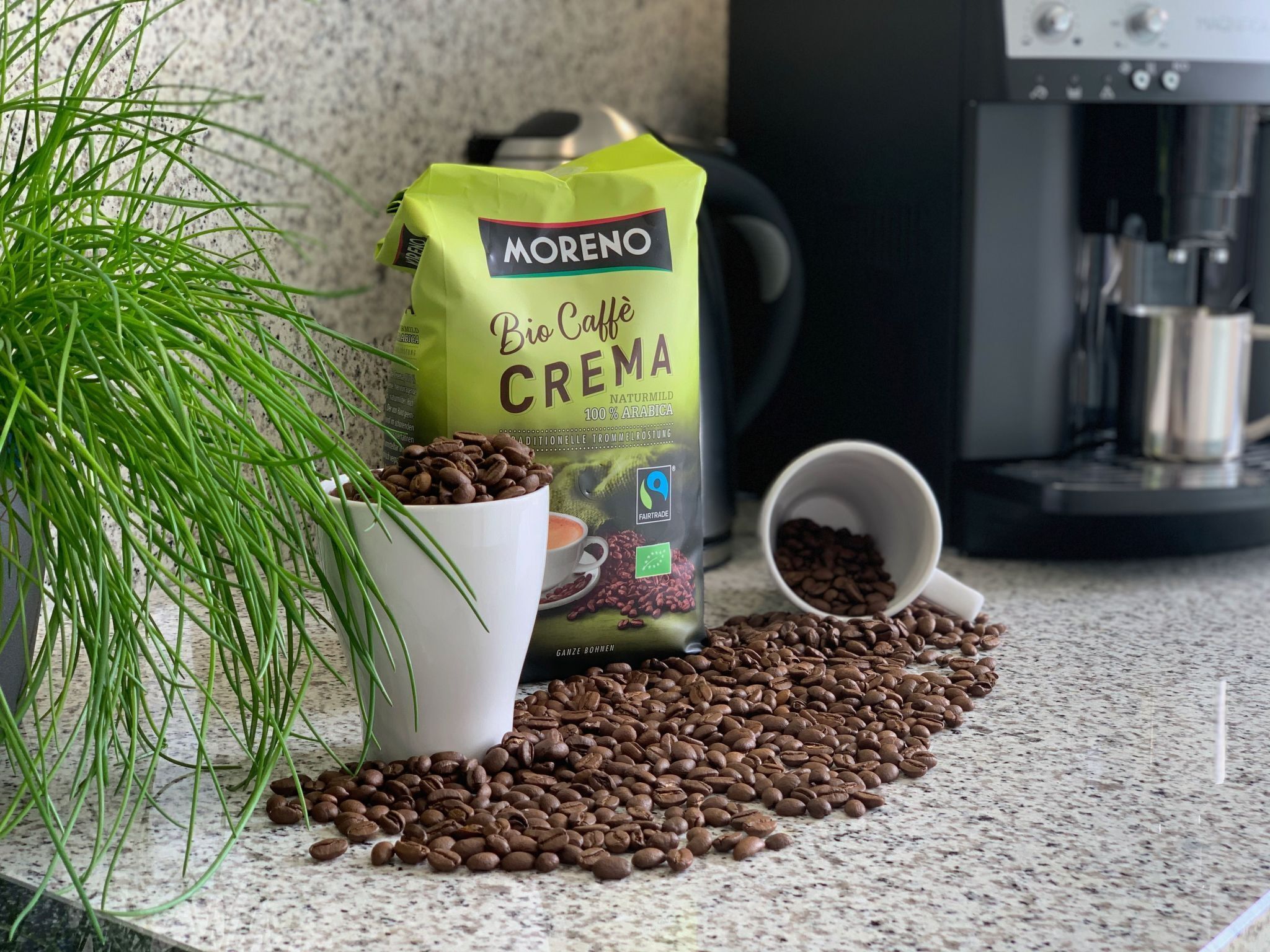 Eine Kaffeepackung, eine weiße Tasse und Kaffeebohnen auf einer Arbeitsplatte.