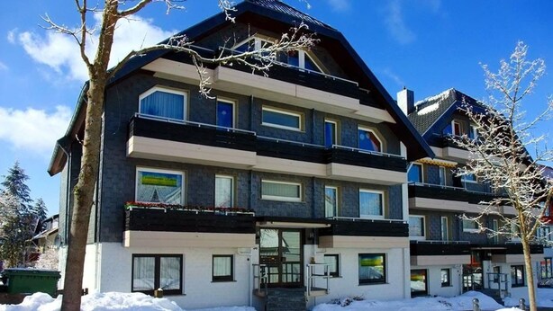 Ein mehrstöckiges Hotel mit modernem Design, mit Balkonen und großen Fenstern.