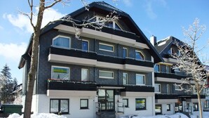 Un hôtel à plusieurs étages doté d’une architecture moderne, avec des balcons et de grandes fenêtres.