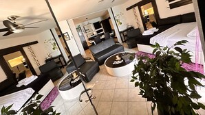 Une chambre d’hôtel moderne équipée d’un lit, d’un canapé, d’un bureau et d’un ventilateur de plafond.