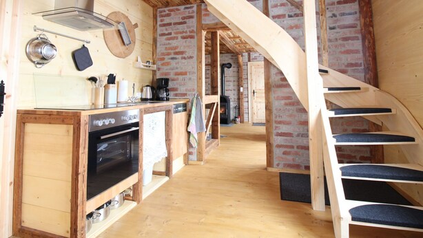 A rustic kitchen with a wooden staircase leading to a loft area. - Anno Dazumal by Interhome (Klingenthal)
