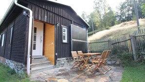A rustic cabin with a stone patio and outdoor furniture. - Anno Dazumal by Interhome (Klingenthal)