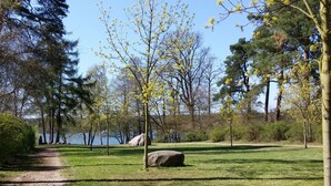 Un parc amb un camí de terra, zones de gespa i arbres.