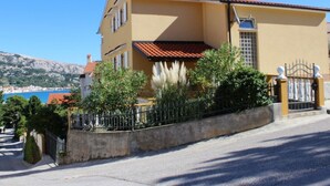 A two-story building with a red-tiled roof, a yellow facade, and a gated entrance. - Appartement in Baška mit Eigenem Balkon by Interhome (Krk/Baška)