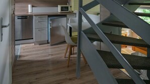 Una cucina funzionale con elettrodomestici moderni, una zona pranzo e una scala che conduce a un piano superiore.
