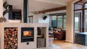 Ein modernes Wohnzimmer mit Kamin, einer Couch und einem Essbereich.