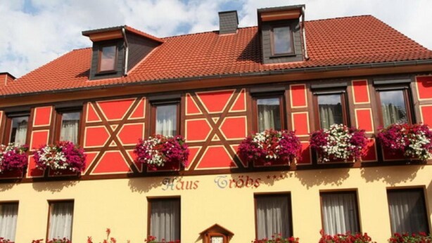A traditional half-timbered building with a red-tiled roof and multiple flower boxes on the facade. - Gästehaus Tröbs by Interhome (Ilfeld)