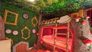 A room with a bunk bed, a ladder, a tree trunk, and a wall with clocks and framed mirrors. - Large 7BR getaway near Disney w/ pool (Kissimmee)