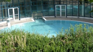 A swimming pool with glass walls, surrounded by greenery. - Gemütliche Ferienwohnung für die ganze Familie by Interhome (Ballenstedt)