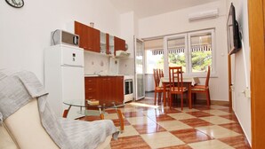 A compact living space with a kitchenette, a dining area, and a sofa. - Appartement in Baška mit Eigenem Balkon by Interhome (Krk/Baška)