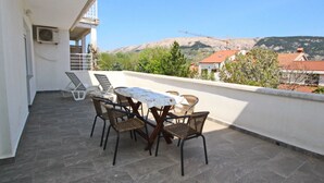 A balcony with a table and chairs, overlooking a mountainous landscape. - Fantov Zarok A4 br.3 by Interhome (Krk/Baška)