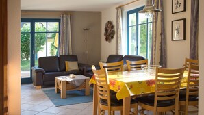 Comedor con una mesa dispuesta para seis personas, rodeada de sillas de madera.