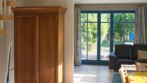 Amplia sala de estar con un mueble de madera, un sofá y una mesa de comedor.