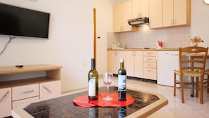 Una cucina moderna con mobili in legno, forno a incasso e zona pranzo con tavolo e sedie.