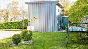 A small shed with a flag, a bench, and neatly trimmed bushes. - Ferienhaus Claire am Klostersee Urlaub mit Hund by Interhome (Dargun)
