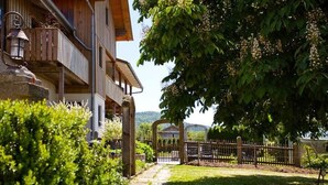 A wooden building with a balcony, a stone lantern, and a pathway leading to a gate. - Am Rückerlhof -Alexi by Interhome (Geigant)