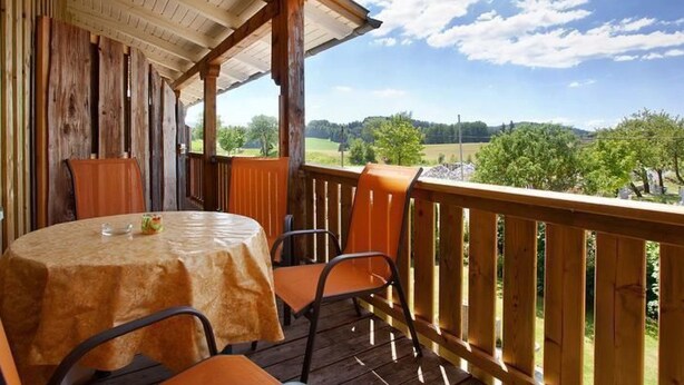 A covered outdoor seating area with a table and chairs, overlooking a scenic landscape. - Am Rückerlhof -Alexi by Interhome (Geigant)