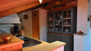 Eine Küche mit Holzarbeitsplatte, Spüle und einem Schrank mit Glastüren.
