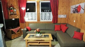 A cozy living room with a green sofa, a wooden coffee table, and a television on a wooden stand. - Vacation home Sophie by Interhome (Extertal)