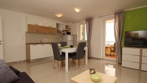 Un appartement moderne comprenant un coin repas, une cuisine et un espace de vie.