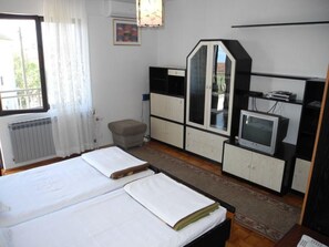 A bedroom with a bed, a TV, a cabinet, and a radiator. - Appartement mit Balkon und Meerblick by Interhome (Crikvenica)