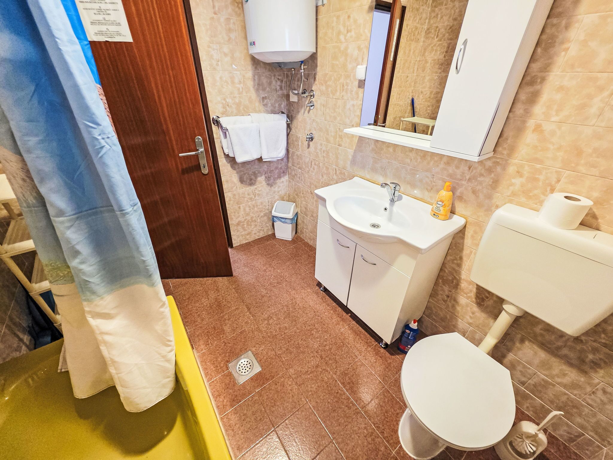 Une salle de bain avec un lavabo, des toilettes et un miroir.