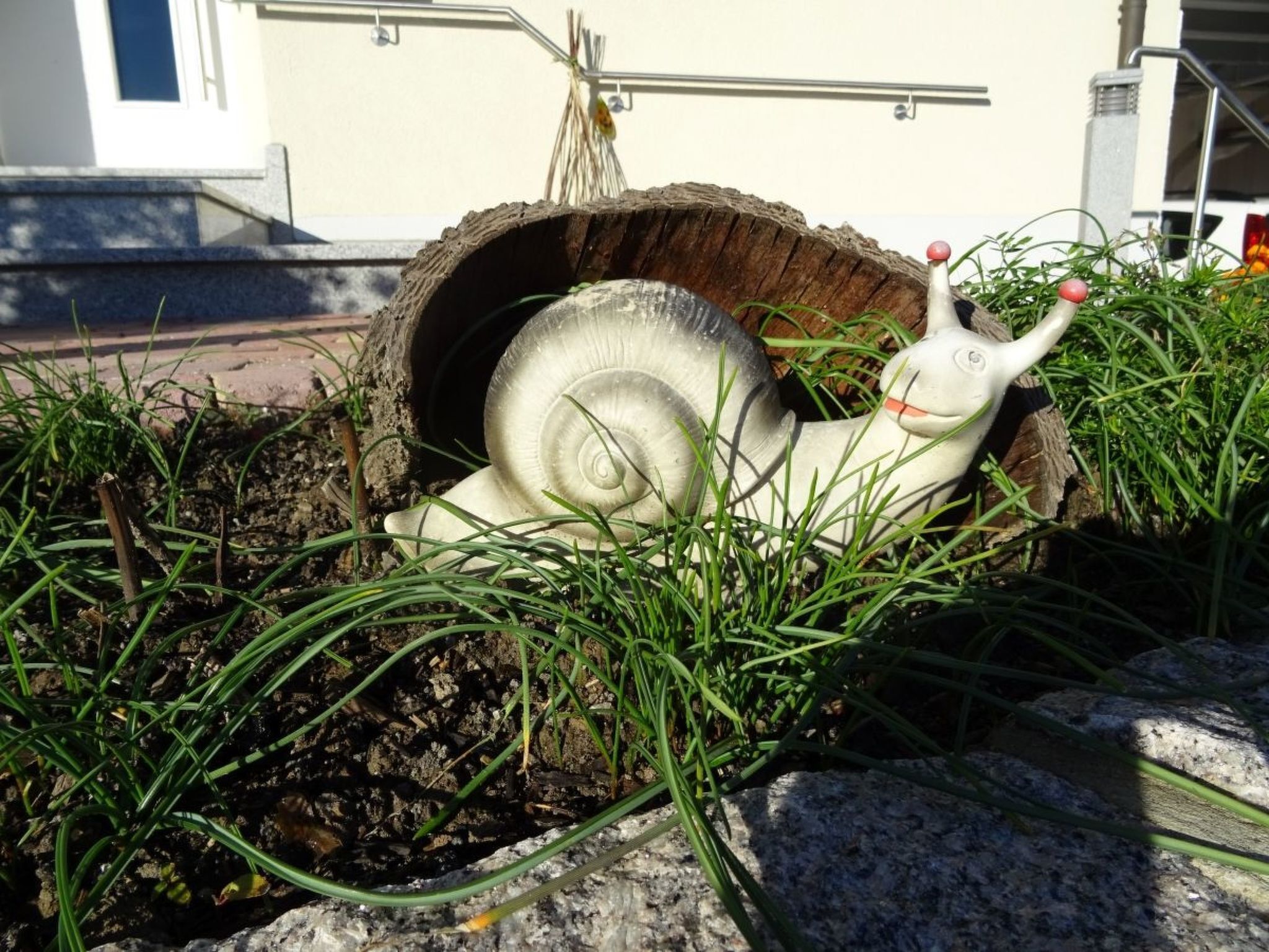 A snail sculpture in a garden setting.