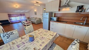 Ein kompakter Wohnraum mit Essbereich, Küchenzeile und einer Couch im Wohnzimmer.