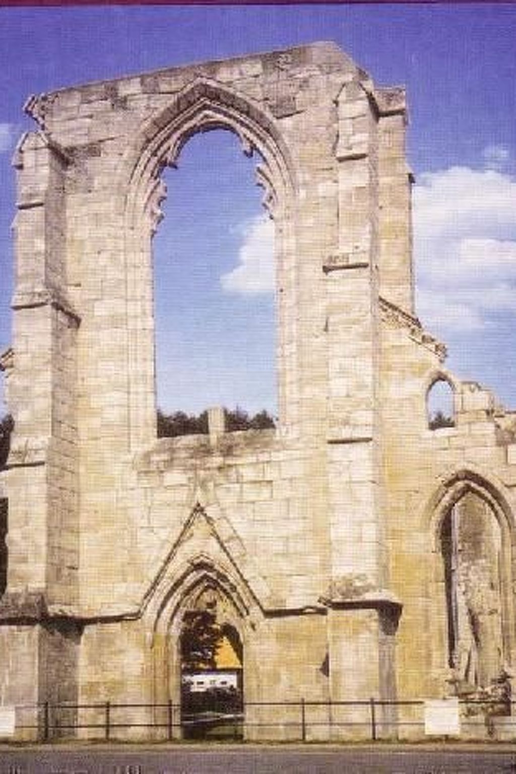 A large, historic stone structure with arched windows and a central doorway.