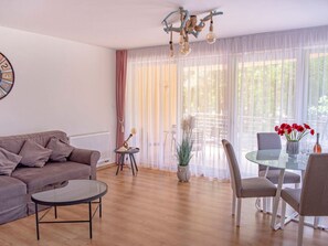 Uma sala de estar moderna com sofá, mesa de centro e área de jantar com cadeiras e mesa.