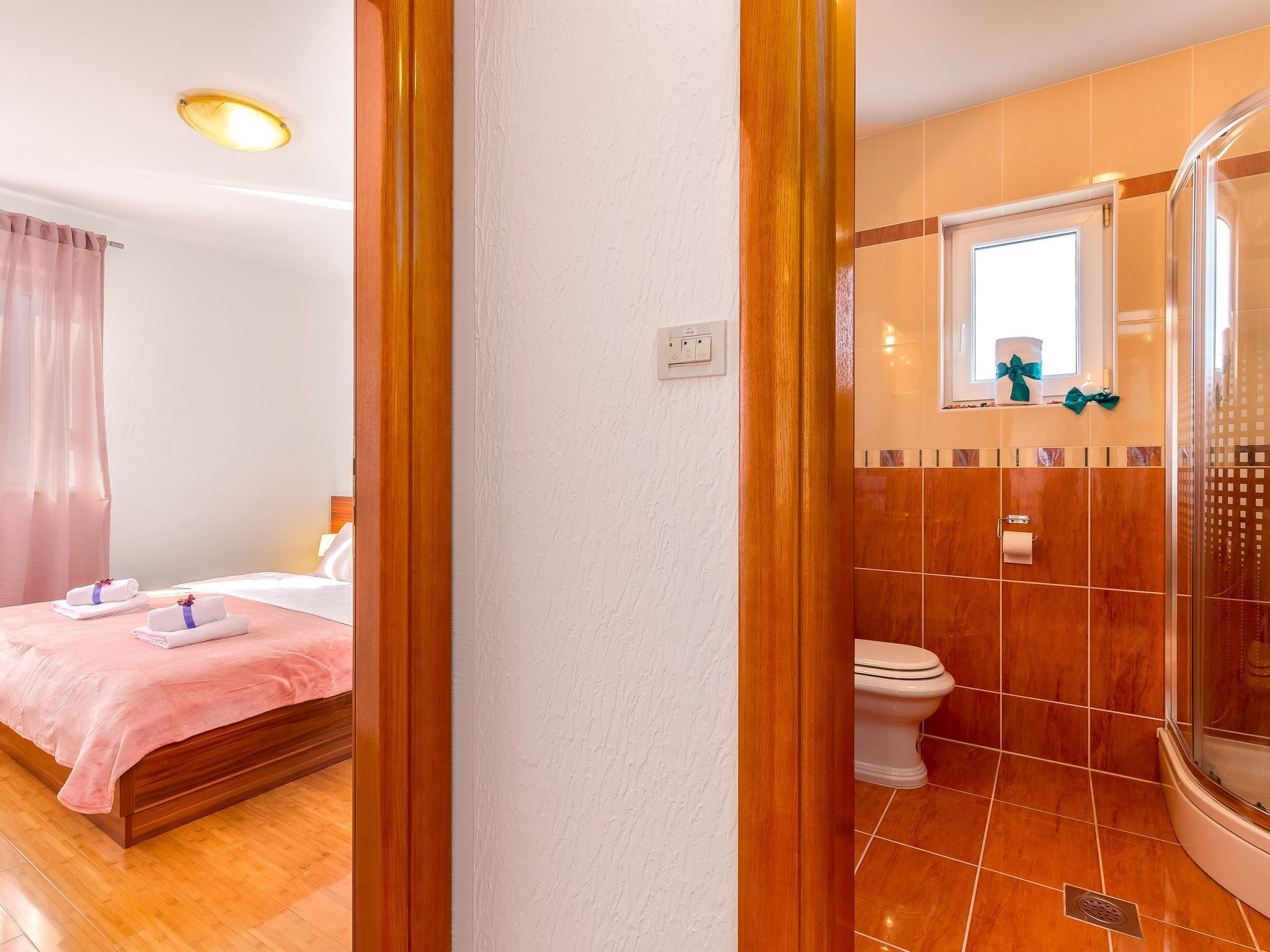 Una habitación de hotel con cama, baño con ducha y ventana.
