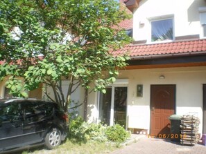 A two-story building with a red-tiled roof, a black car parked in front, and a date stamp of 10/06/2012. - Charmantes Haus 100m vom Strand entfernt für 6 Personen by Interhome (Pobierowo)