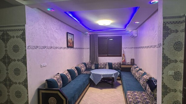 A room with a sofa set, a small table, and patterned walls. - Residence Ennassr 3 by Interhome (Agadir)