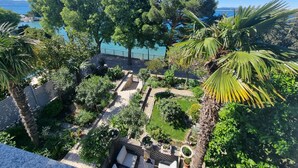 A garden with a seating area, a pathway, and a view of the sea. - Wohnung 10m vom Strand entfernt by Interhome (Crikvenica)