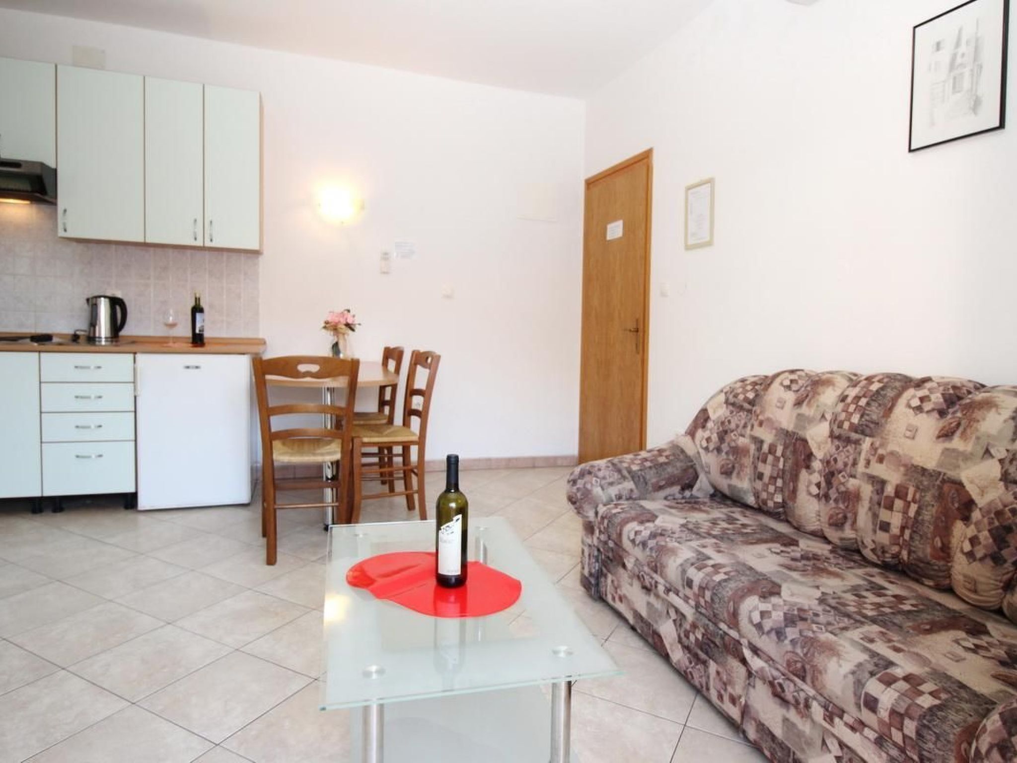 A compact living space with a kitchenette, a dining area, and a sofa.