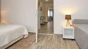 Une chambre d’hôtel avec deux lits, une petite table avec une lampe et une vue sur la salle à manger.