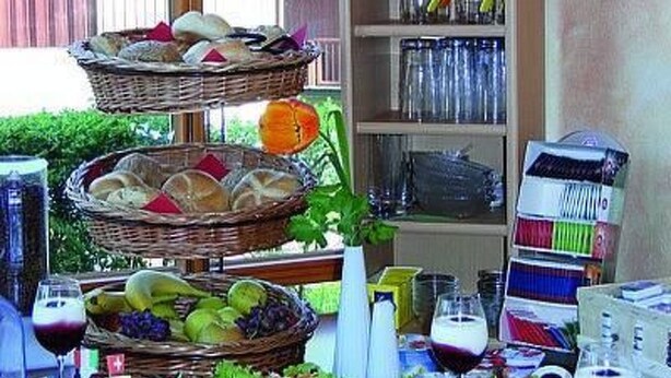 A dining table set with various food items, wine glasses, and a basket of bread. - Dream Apartment by Interhome (Rötz)