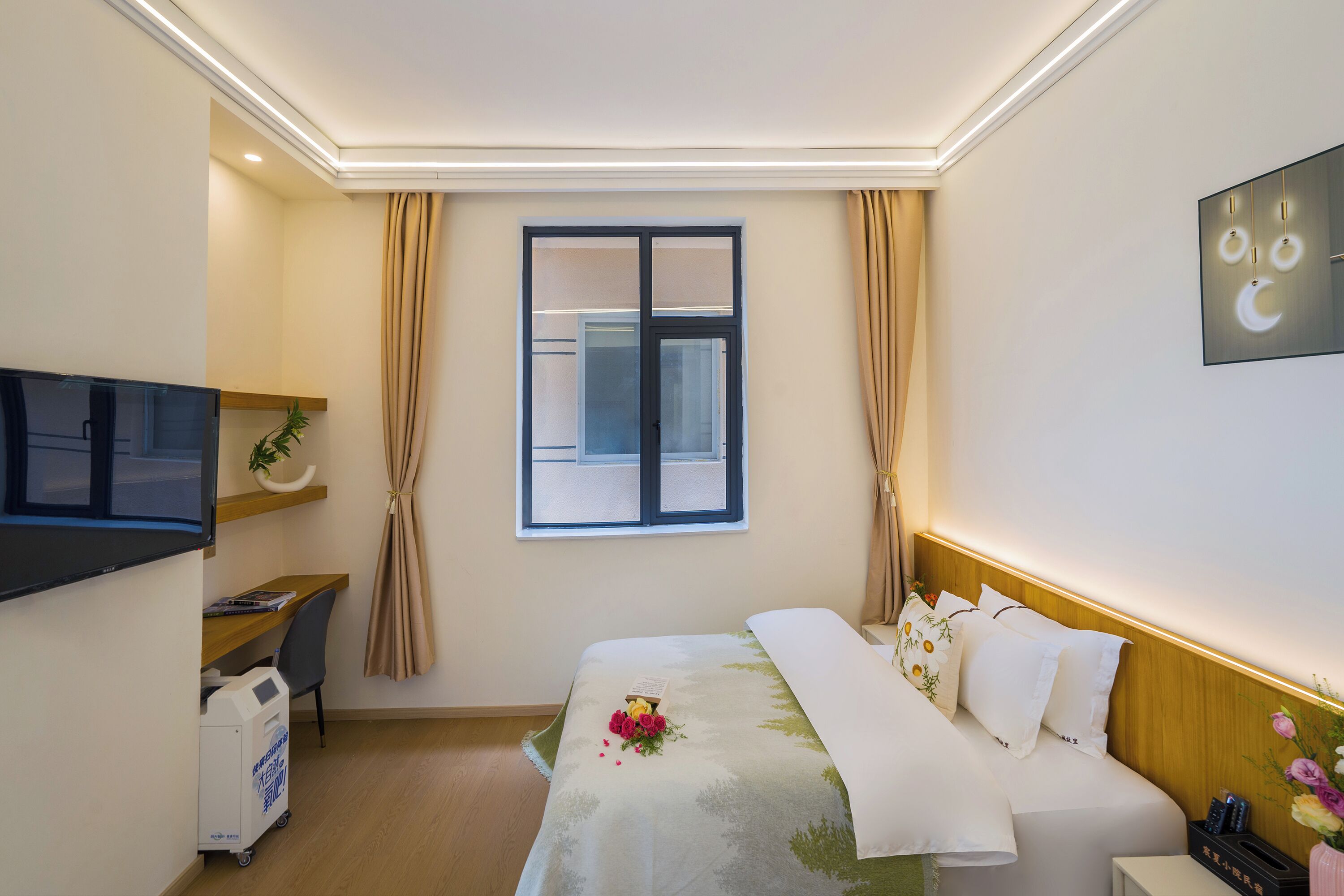 Habitación de hotel con cama, escritorio, televisor, ventana con cortinas y una obra de arte en la pared.