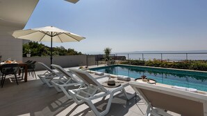 A rooftop pool area with lounge chairs, a table with drinks, and a view of the sea. - Villa inmitten der Natur in ruhiger Lage by Interhome (Makarska)