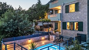 Un edificio moderno con piscina, zona de estar al aire libre y balcón.