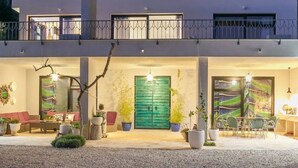 A two-story building with a balcony, a green door, and outdoor seating. - Stylische Villa -Tres Chic- in Makarska by Interhome (Makarska)