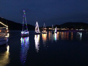 Een verlichte jachthaven bij nacht, met stilstaand water.