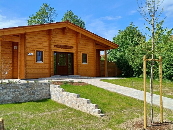 A wooden cabin with a stone retaining wall and a paved driveway. - Blauvogel by Interhome (Hasselfelde)