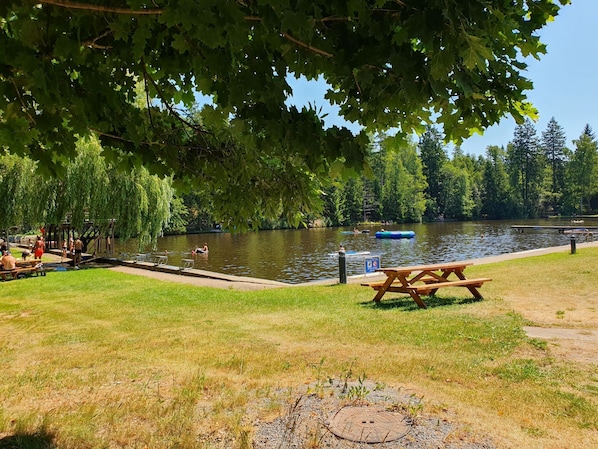 A lakeside park with picnic tables, a dock, and people engaging in water activities. - Blauvogel by Interhome (Hasselfelde)