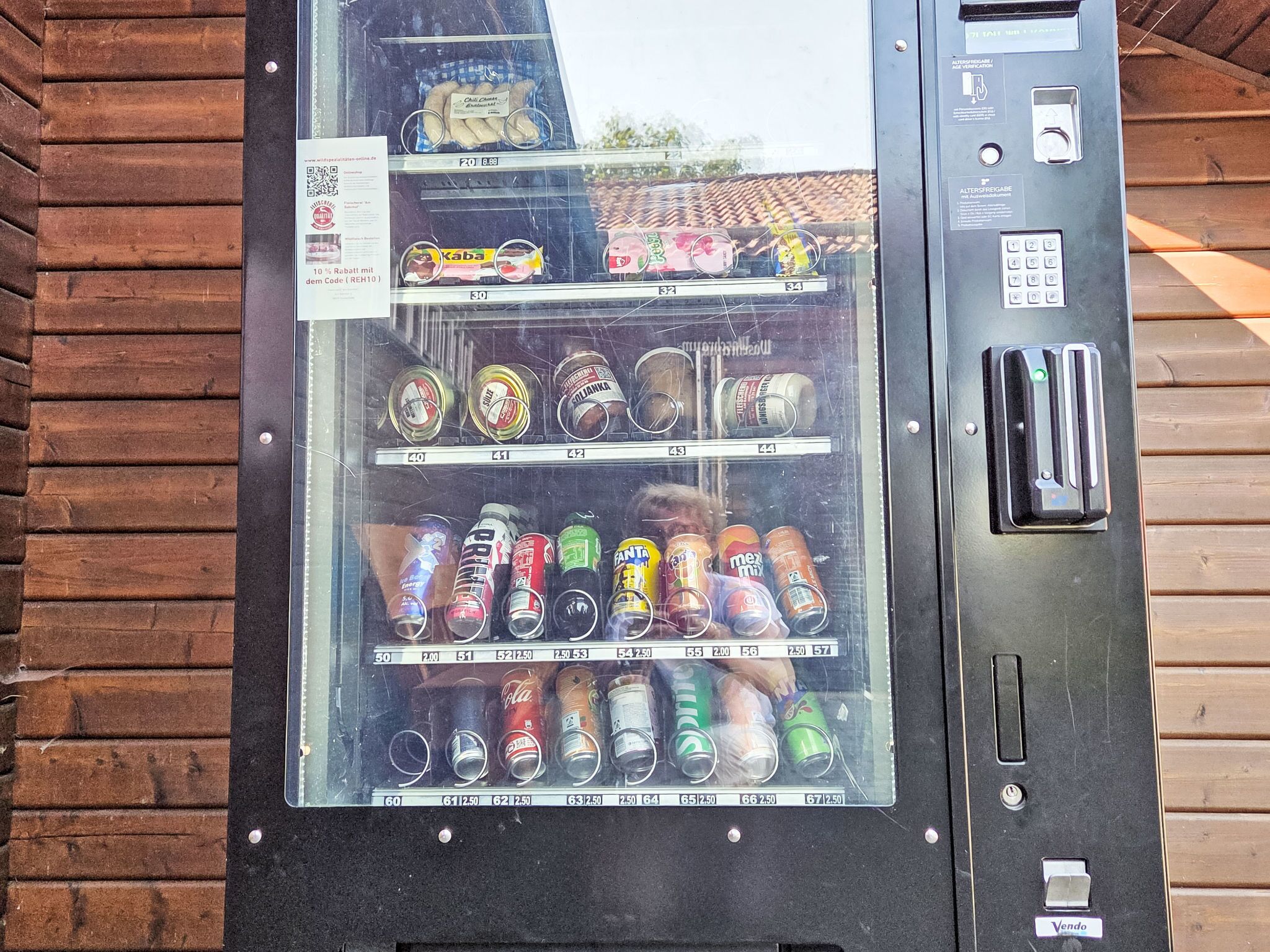 Un distributeur automatique proposant une variété de boissons en conserve et de collations.