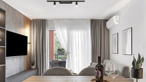 A modern living room with a wooden dining table, a mounted flat-screen TV, and a large window with sheer curtains. - Apartment Ana Makarska by Interhome (Makarska)