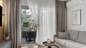 A modern living room with a sofa, a coffee table, and a view of an outdoor patio area. - Apartment Ana Makarska by Interhome (Makarska)