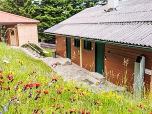 Un bâtiment doté d’un toit en pente et d’un petit escalier menant à une porte.