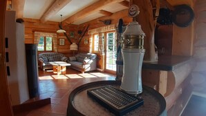 A cozy log cabin interior with a fireplace, a sofa, and a dining table. - Schönberghütte by Interhome (Niederwölz)