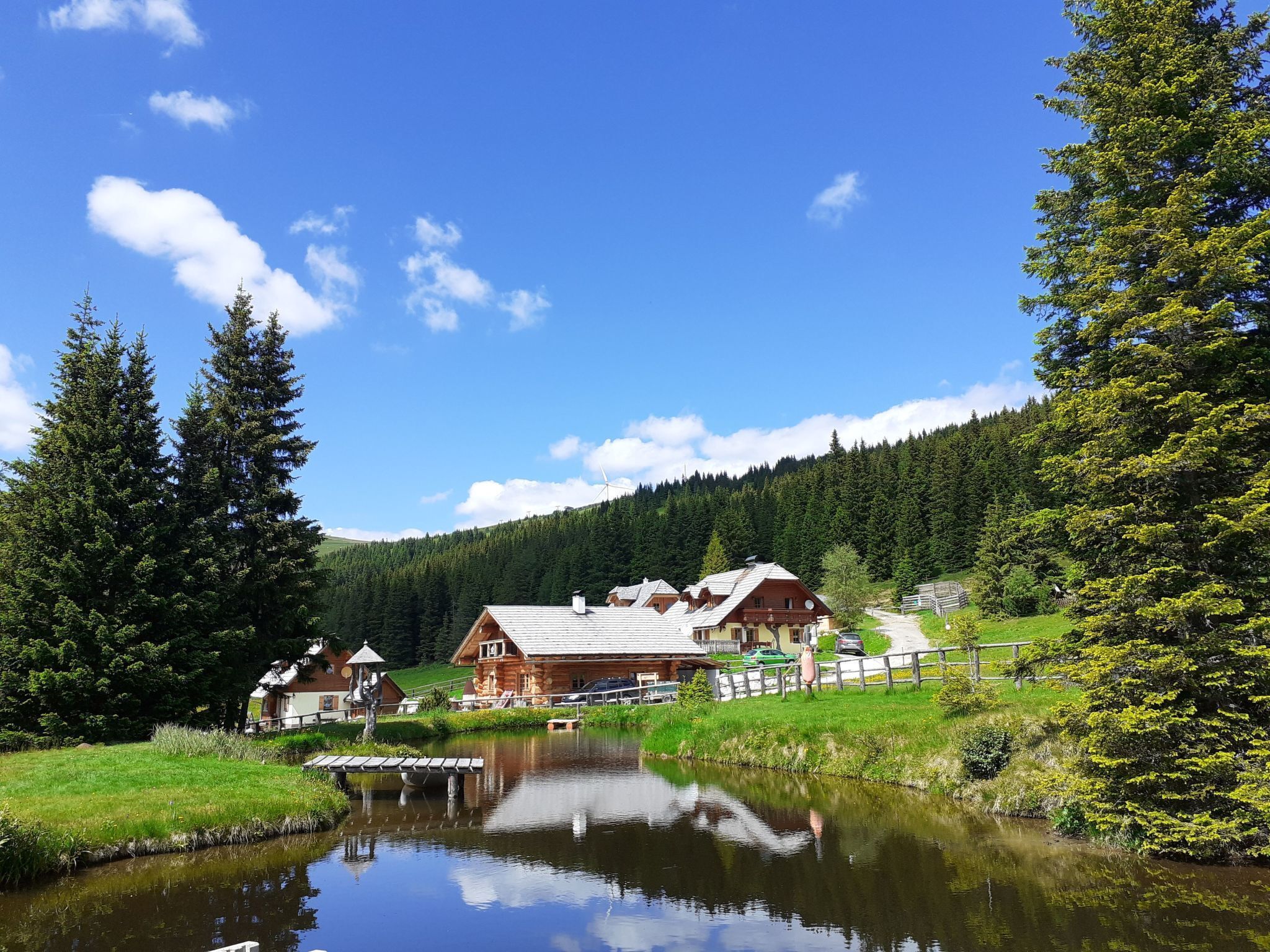 A lakeside cabin with a wooden deck and a small dock extending into the water.